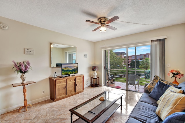 living room featuring ceiling fan and a textured ceiling