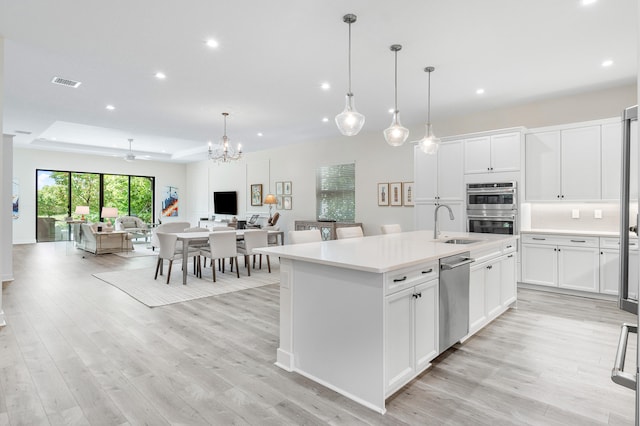 kitchen featuring white cabinets, a kitchen island with sink, and stainless steel appliances