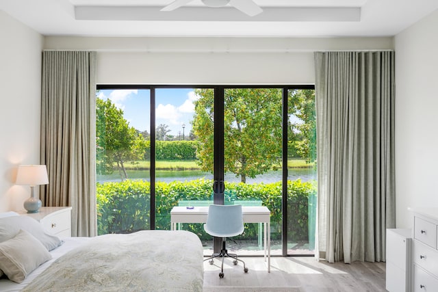 bedroom featuring a water view, access to exterior, ceiling fan, and light hardwood / wood-style flooring