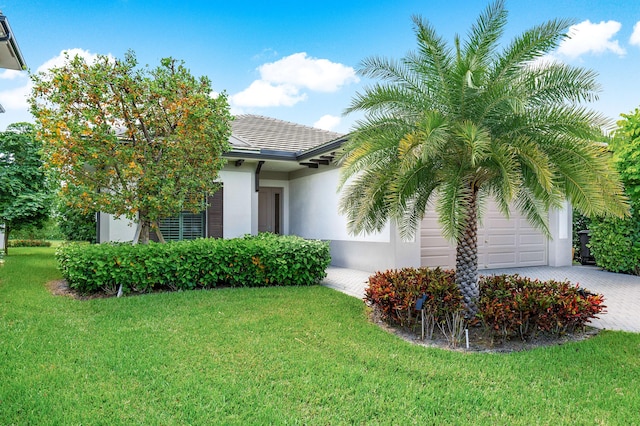 view of front of home with a garage and a front lawn