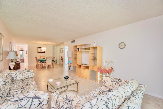 living room with light hardwood / wood-style floors and a textured ceiling