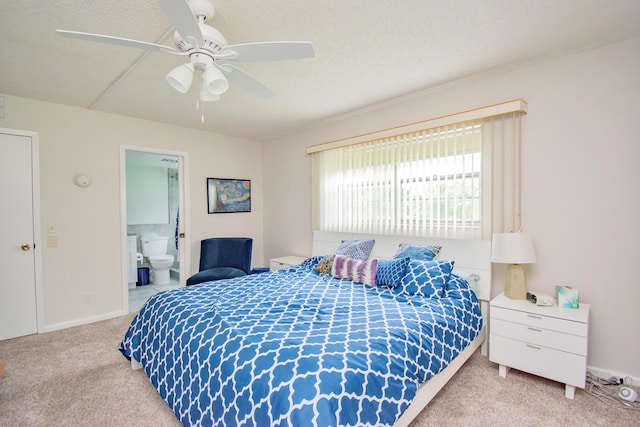 carpeted bedroom with a textured ceiling, connected bathroom, and ceiling fan