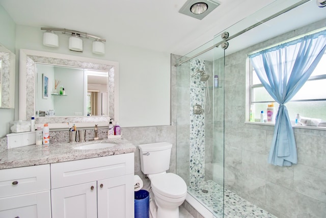 bathroom with an enclosed shower, vanity, and toilet