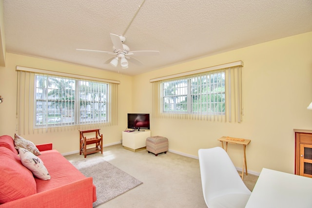 carpeted office space featuring a wealth of natural light, ceiling fan, and a textured ceiling