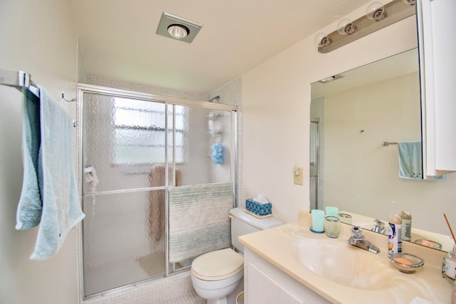 bathroom featuring an enclosed shower, vanity, and toilet