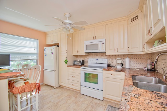 kitchen featuring backsplash, white appliances, light stone countertops, ceiling fan, and sink