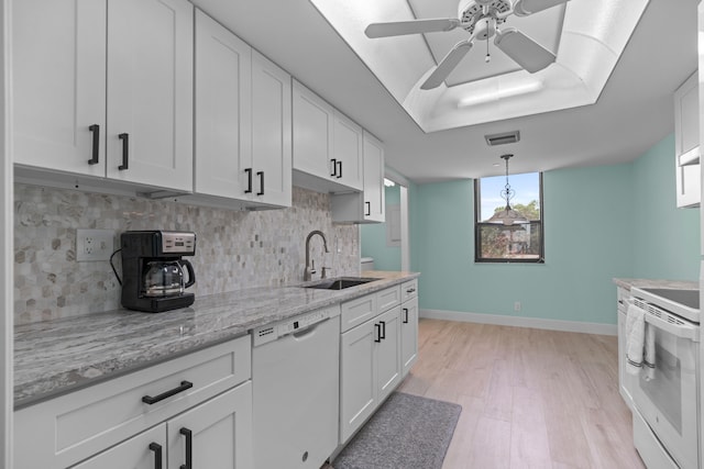 kitchen with sink, tasteful backsplash, white dishwasher, white cabinets, and range