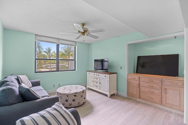 living room with a textured ceiling, light hardwood / wood-style flooring, and ceiling fan