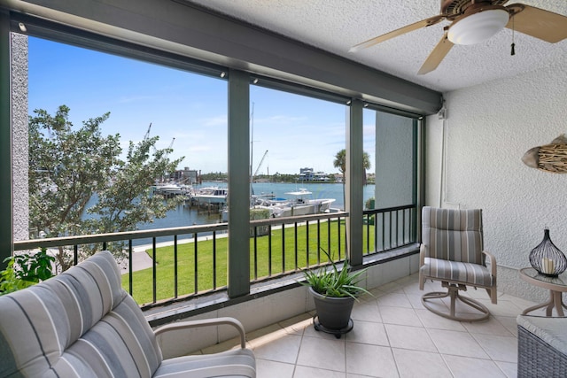 sunroom featuring a water view, a wealth of natural light, and ceiling fan