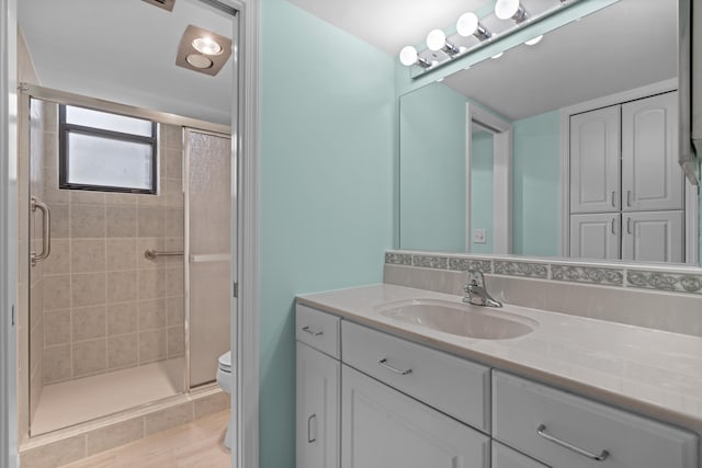 bathroom featuring tile patterned floors, vanity, an enclosed shower, and toilet