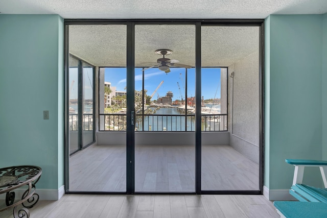 interior space with a water view and ceiling fan