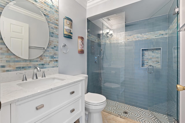 bathroom with vanity, a shower with door, crown molding, tile patterned flooring, and toilet