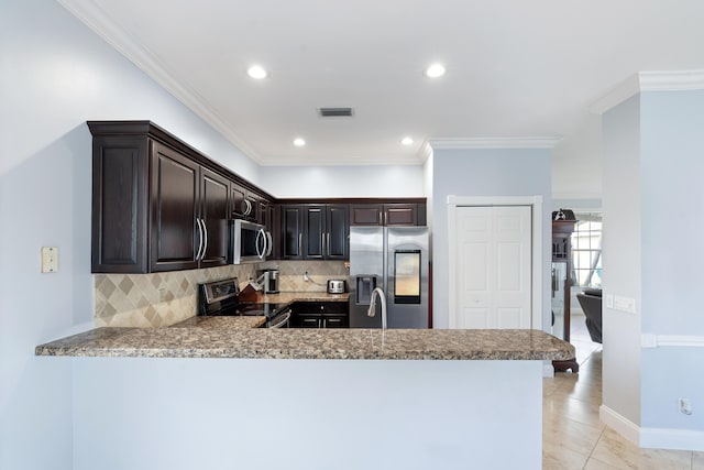 kitchen with kitchen peninsula, decorative backsplash, stainless steel appliances, and ornamental molding