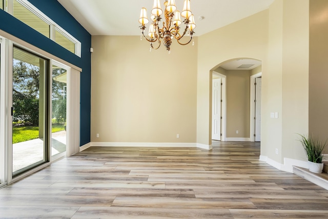 unfurnished room with light hardwood / wood-style floors and a notable chandelier