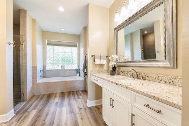 bathroom featuring hardwood / wood-style floors, vanity, and independent shower and bath