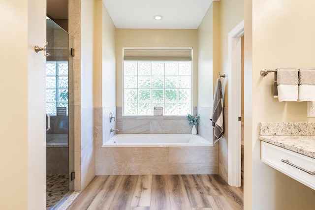 full bathroom featuring separate shower and tub, vanity, wood-type flooring, and toilet