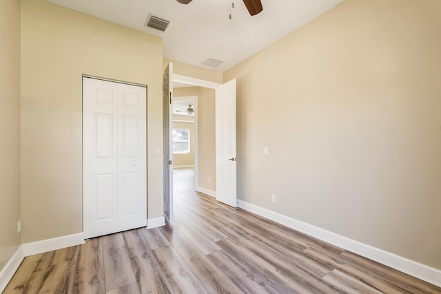 unfurnished bedroom featuring light hardwood / wood-style flooring, a closet, and ceiling fan