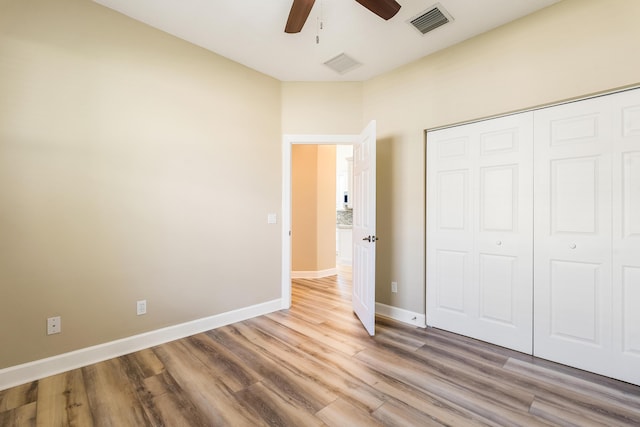 unfurnished bedroom with ceiling fan, light hardwood / wood-style floors, and a closet