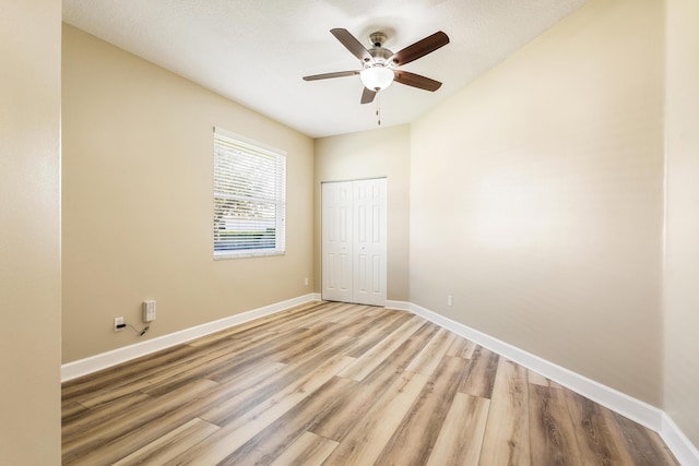 unfurnished bedroom featuring light wood-type flooring, a closet, and ceiling fan