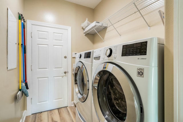 washroom with independent washer and dryer and light hardwood / wood-style floors