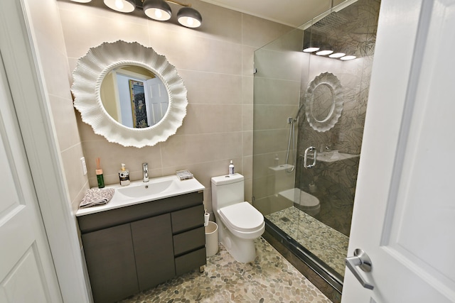 bathroom featuring toilet, an enclosed shower, tile walls, backsplash, and vanity