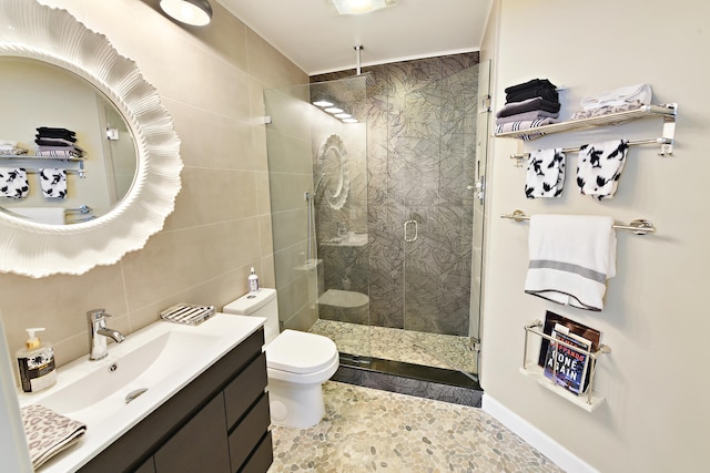 bathroom featuring walk in shower, tile walls, vanity, and toilet