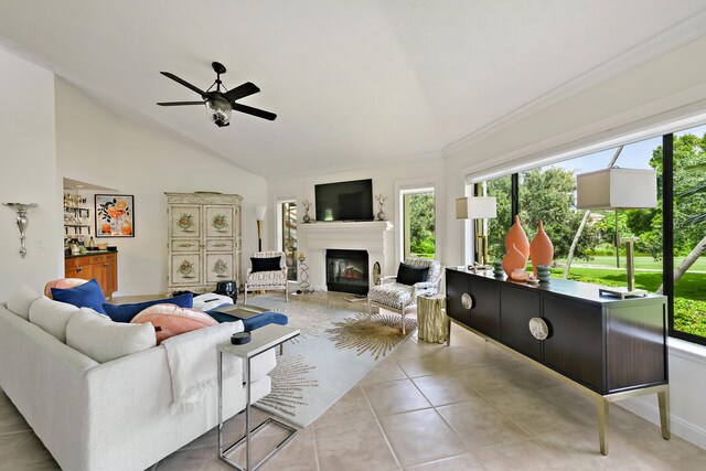 tiled living room featuring crown molding, vaulted ceiling, and ceiling fan