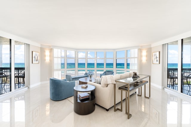 living room with a wall of windows, a water view, and a wealth of natural light