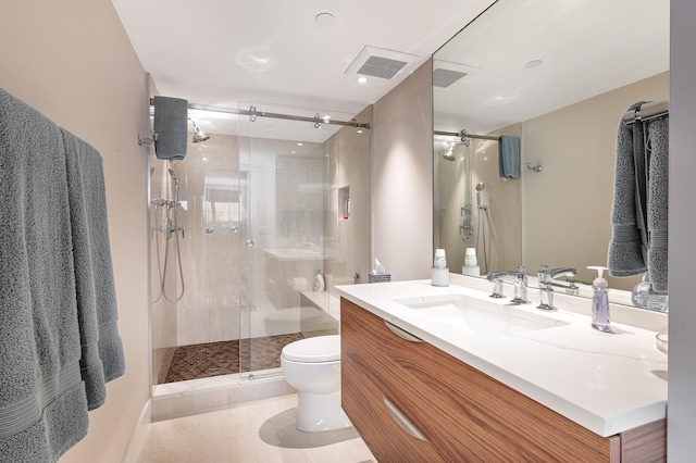 bathroom featuring tile patterned flooring, a shower with shower door, vanity, and toilet