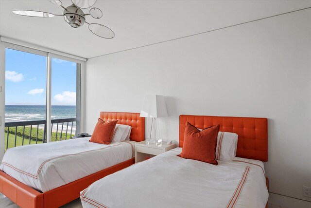 bedroom featuring a view of the beach, floor to ceiling windows, and a water view