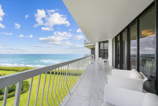 balcony with a water view and a beach view