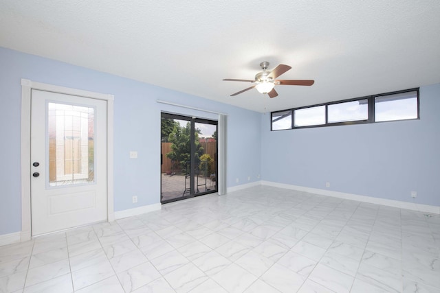 unfurnished room featuring ceiling fan and a textured ceiling