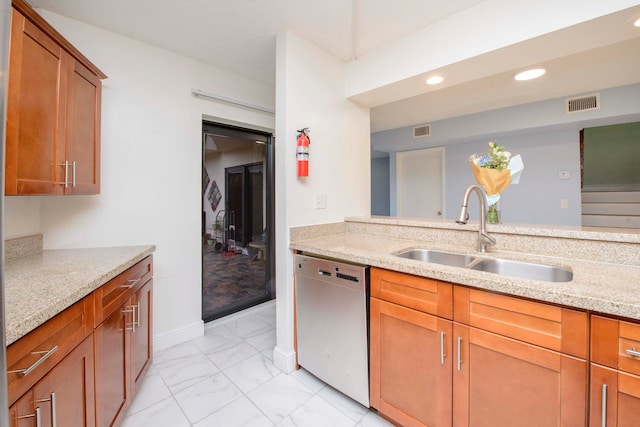 kitchen with dishwasher, light stone countertops, and sink