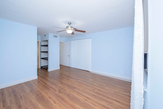 interior space with ceiling fan, wood-type flooring, and a textured ceiling