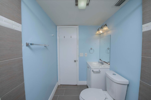 bathroom featuring tile patterned floors, vanity, tile walls, and toilet