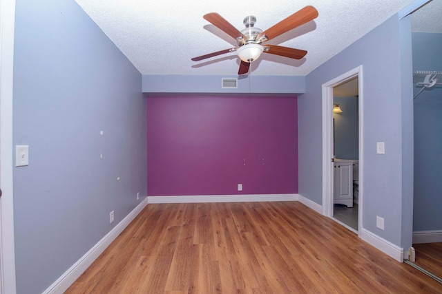 unfurnished bedroom with ceiling fan, a closet, a textured ceiling, and light wood-type flooring