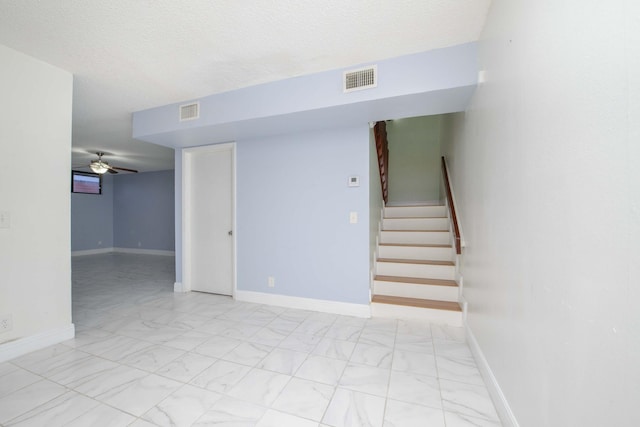 interior space with ceiling fan and a textured ceiling