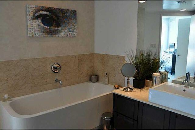 bathroom featuring vanity and a washtub