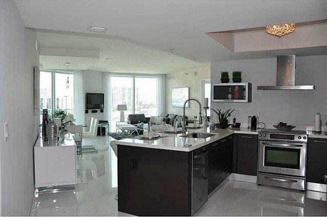 kitchen featuring black dishwasher, sink, kitchen peninsula, stainless steel electric range oven, and wall chimney range hood