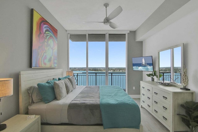 bedroom with light hardwood / wood-style flooring, floor to ceiling windows, ceiling fan, and access to exterior