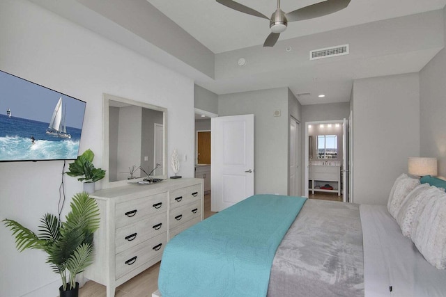 bedroom with connected bathroom, ceiling fan, and light hardwood / wood-style flooring