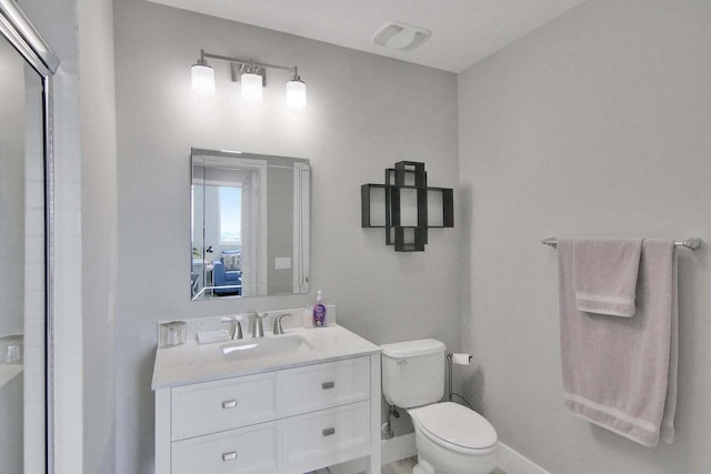 bathroom with vanity, toilet, and a shower with door