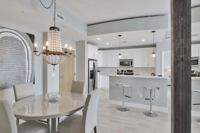 dining room with a notable chandelier and light hardwood / wood-style flooring