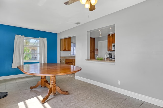 tiled dining area featuring ceiling fan