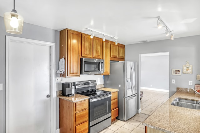 kitchen featuring pendant lighting, track lighting, light tile patterned flooring, sink, and appliances with stainless steel finishes