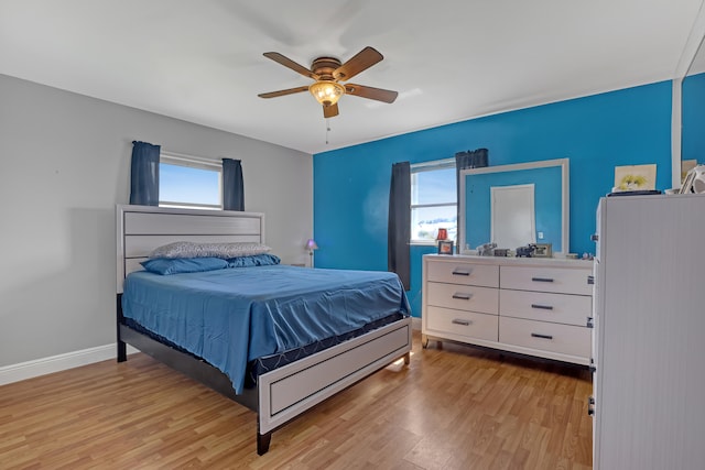 bedroom featuring multiple windows, ceiling fan, and light hardwood / wood-style flooring