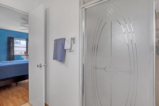 bathroom featuring walk in shower, hardwood / wood-style flooring, and ceiling fan