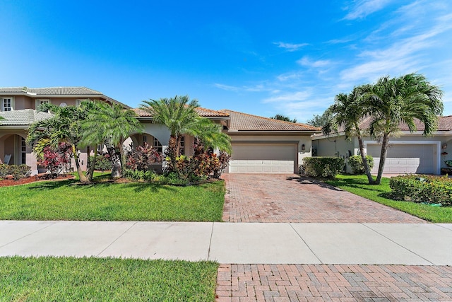 mediterranean / spanish-style home featuring a garage and a front lawn