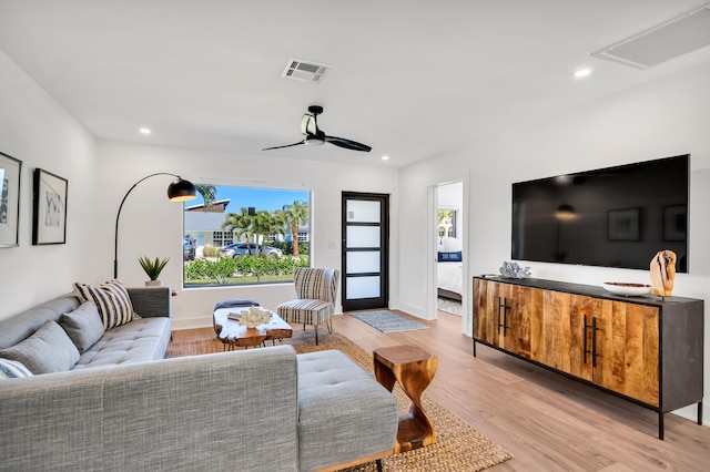 living room with light hardwood / wood-style floors and ceiling fan