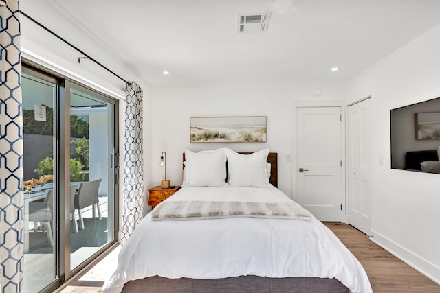 bedroom with hardwood / wood-style floors and access to outside